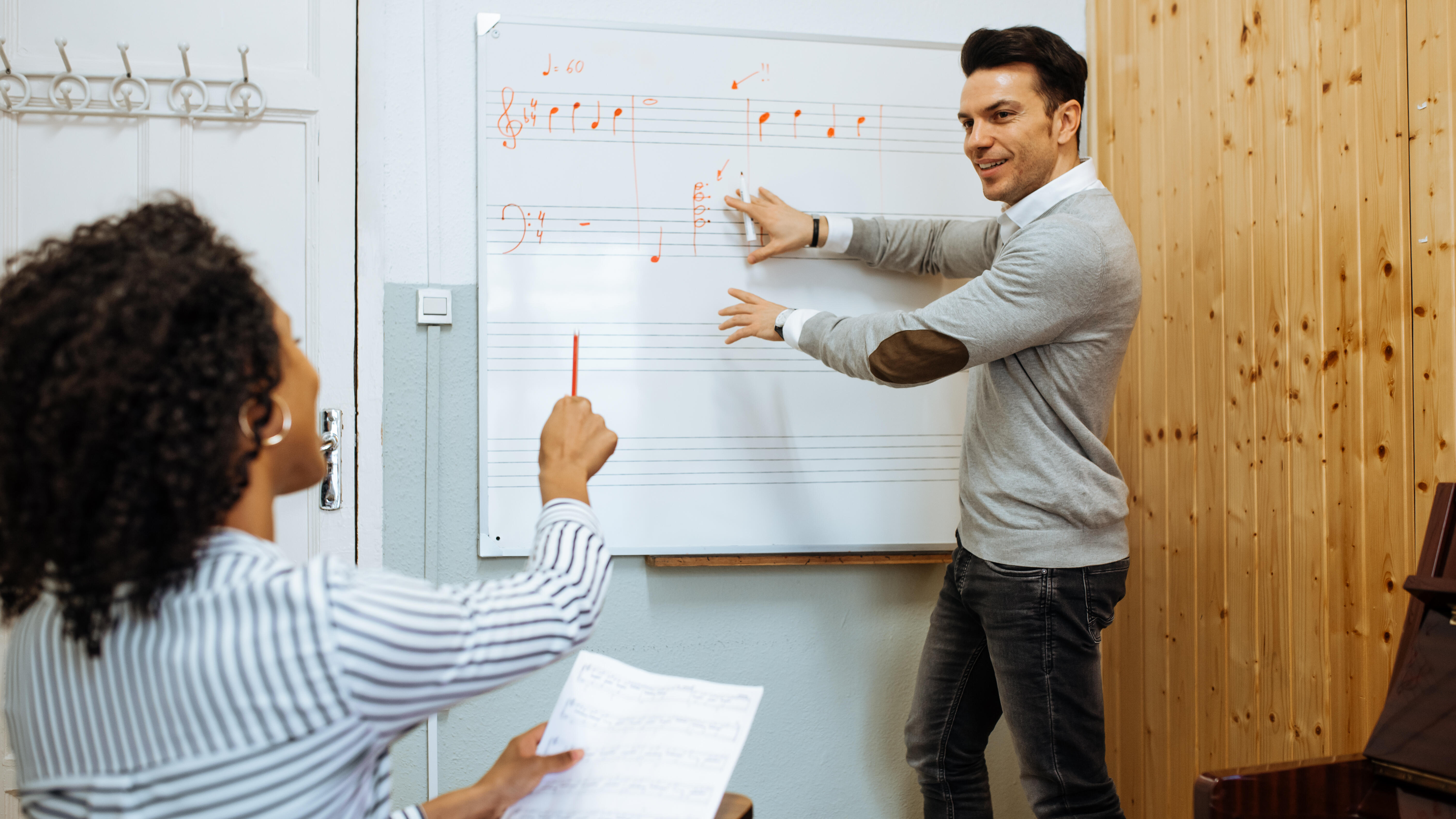 Man teaching woman music notes