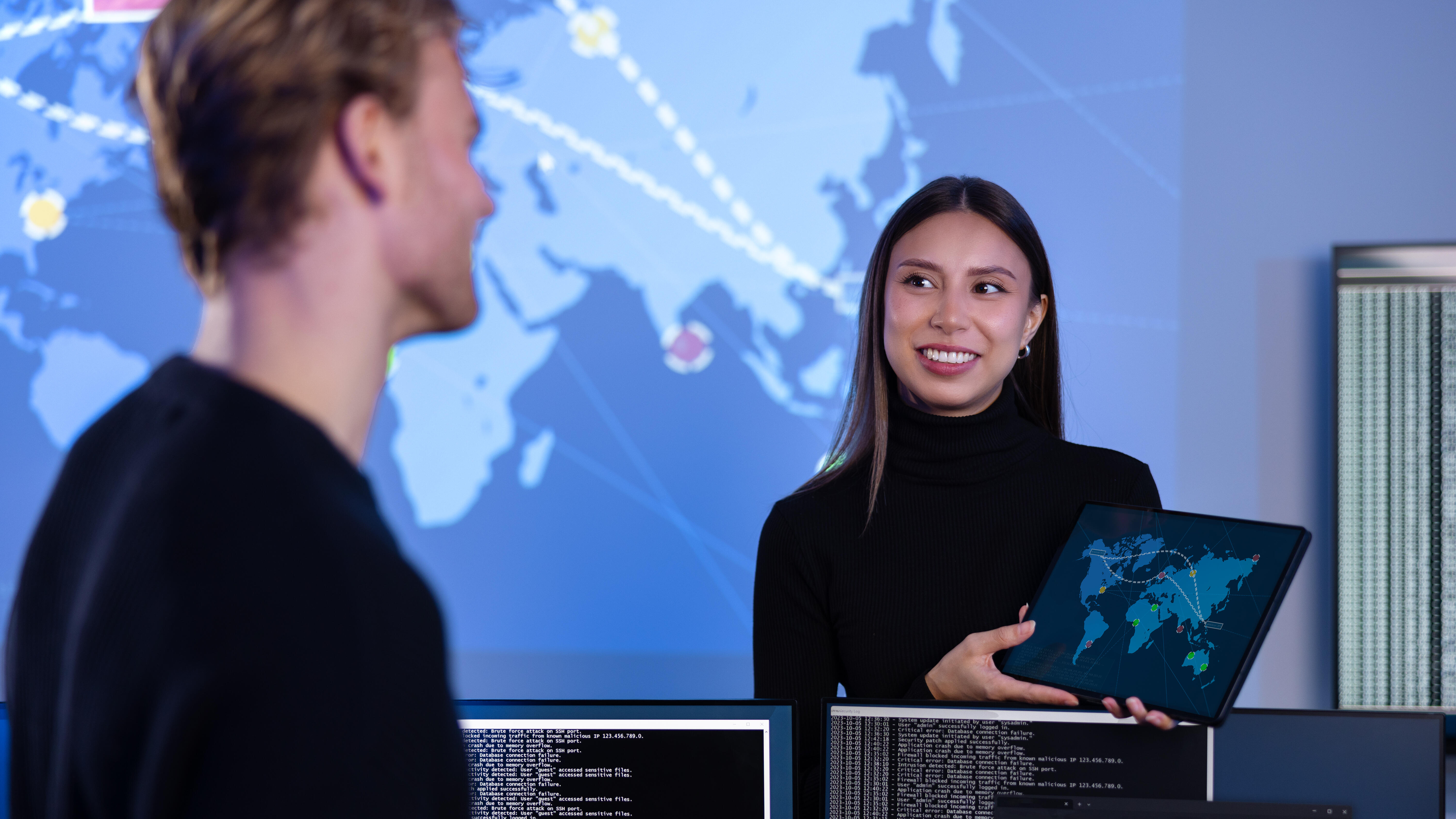 Smiling cyber security team working in a Cyber Security Operations Center SOC to protect systems