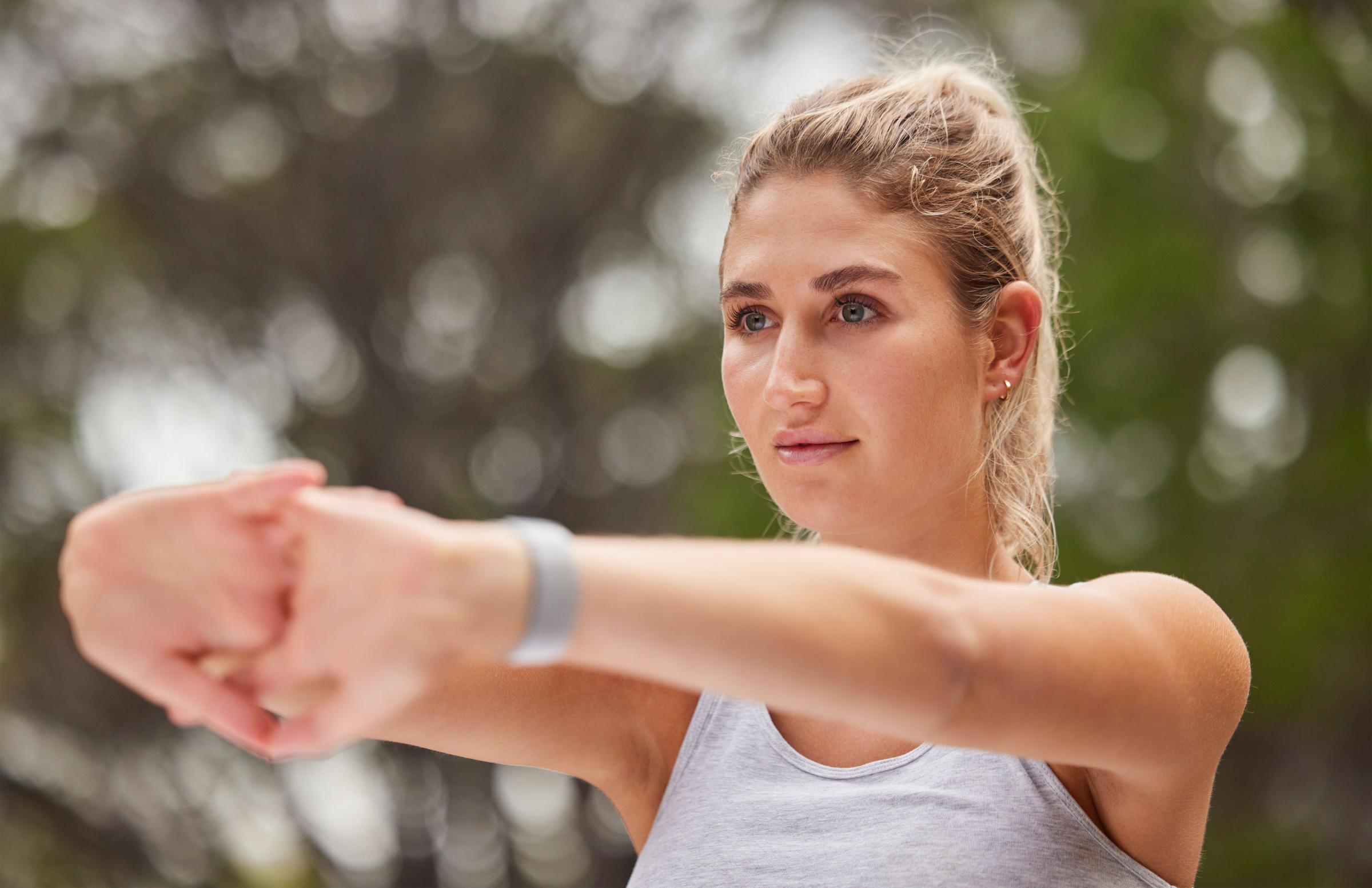 Woman, stretching and fitness outdoor, arm with exercise and workout, ready to run or yoga